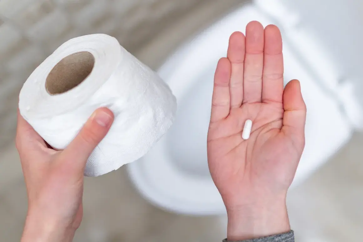 Mano con rotolo carta igienica e capsula bianca, possibile antibiotico per diarrea capre.