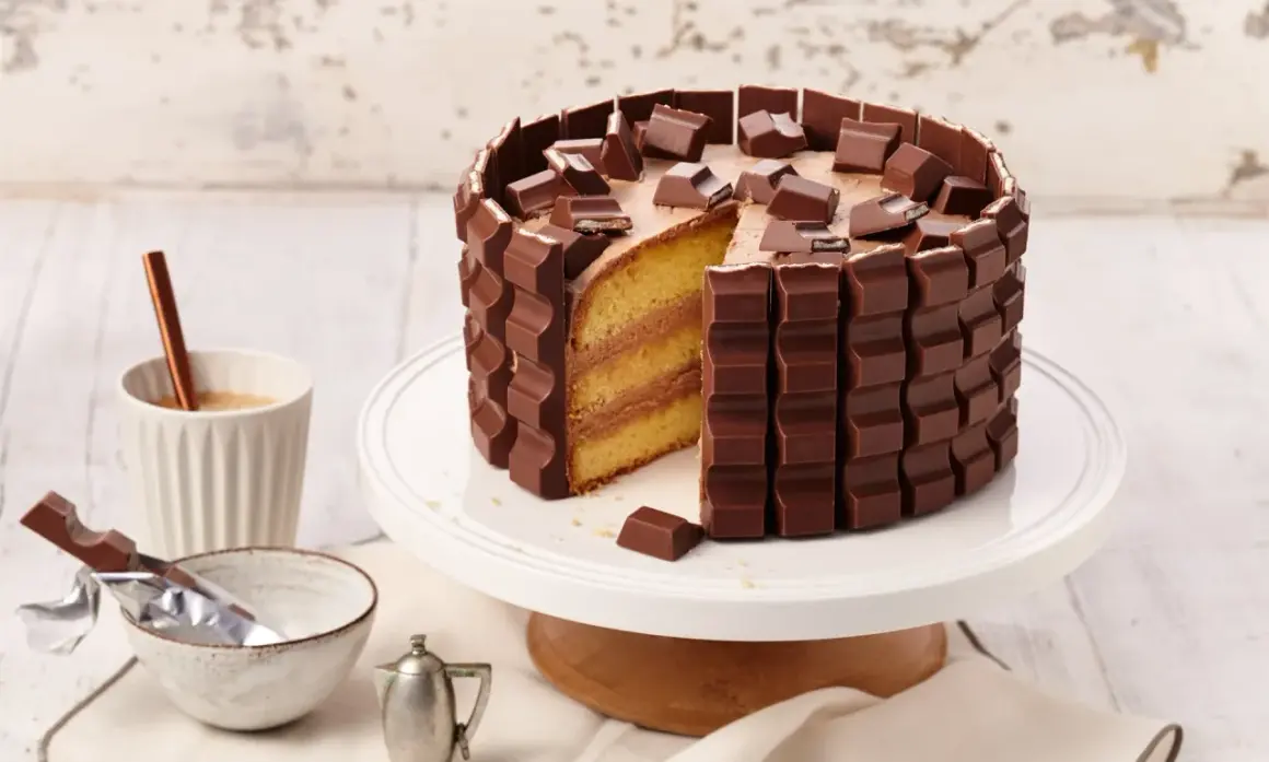Eine köstliche Kinderriegel Torte, umhüllt von Schokoriegeln und garniert mit Stückchen. Ein Traum für jeden Schokoladenliebhaber!
