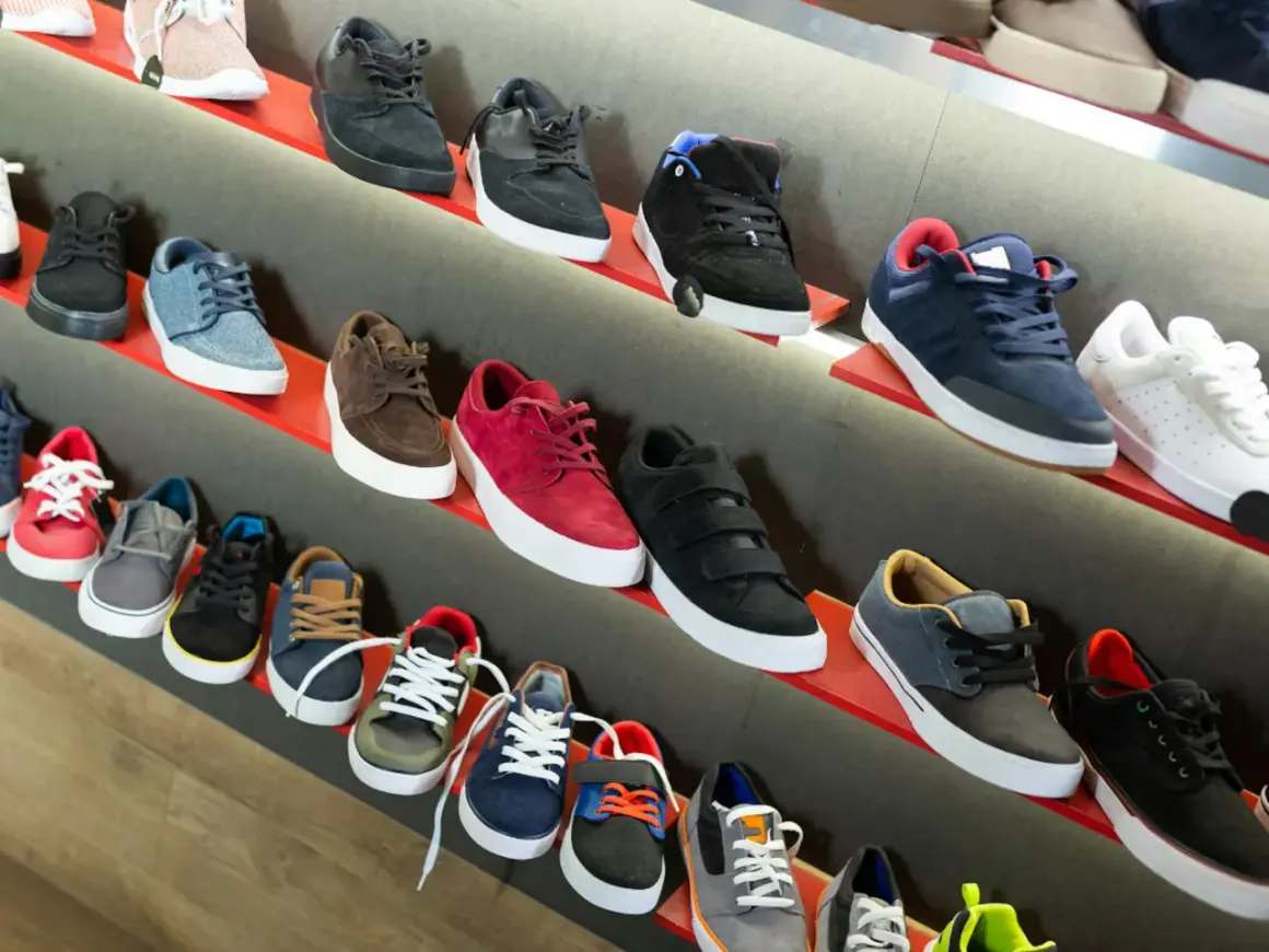 Scaffali pieni di sneakers, tra cui modelli nira rubens, in vari colori e stili, pronte per essere indossate.