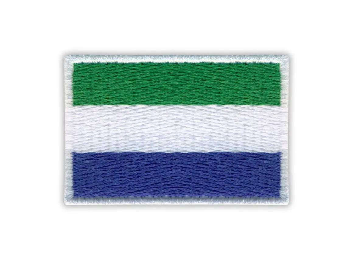 Haftowana flaga Sierra Leone z zielonym, białym i niebieskim pasem.