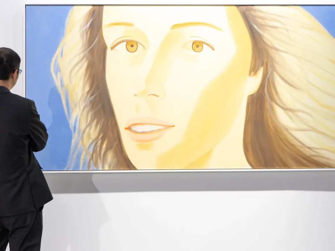 A man in a suit admires a large painting of a woman's face at Art Basel Hong Kong 2026.