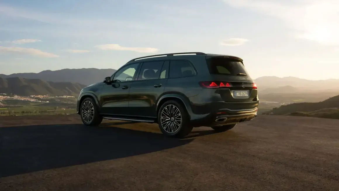 Mercedes más potente, un SUV oscuro aparcado en una colina con vistas a un valle al atardecer.