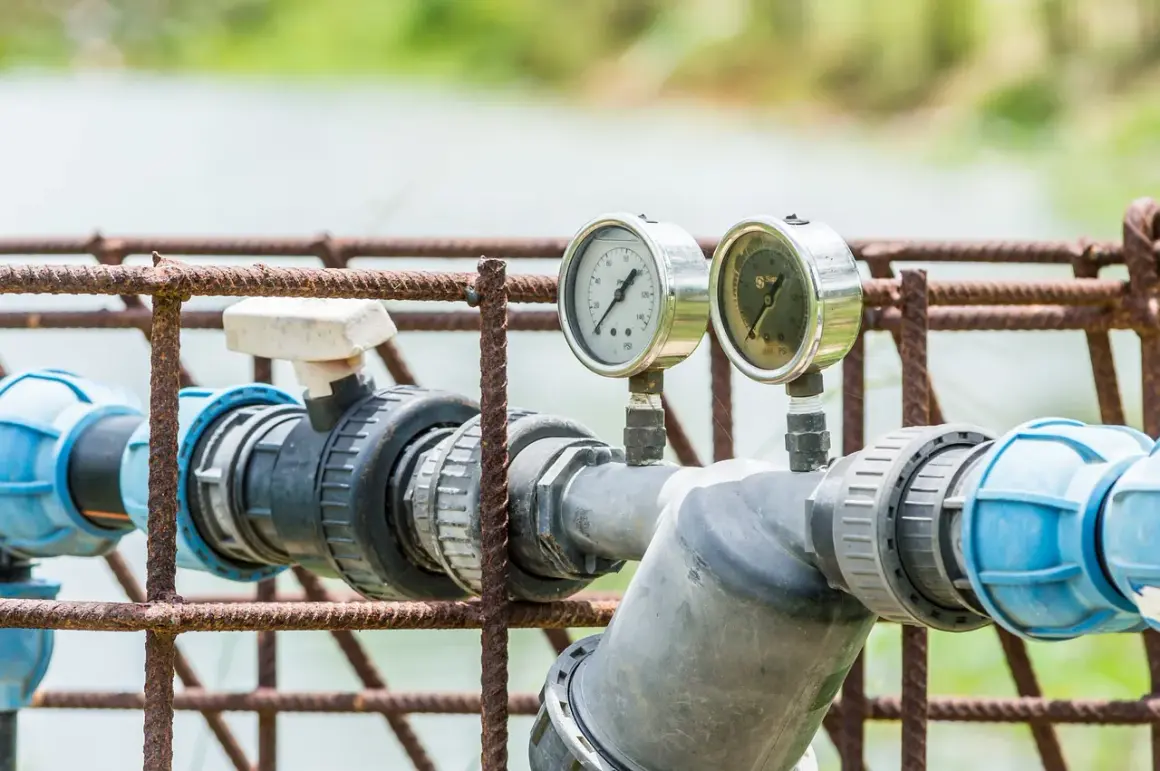 Manomètres sur tuyauterie grise et bleue, rouille sur la structure. Indique un possible problème adoucisseur d'eau.