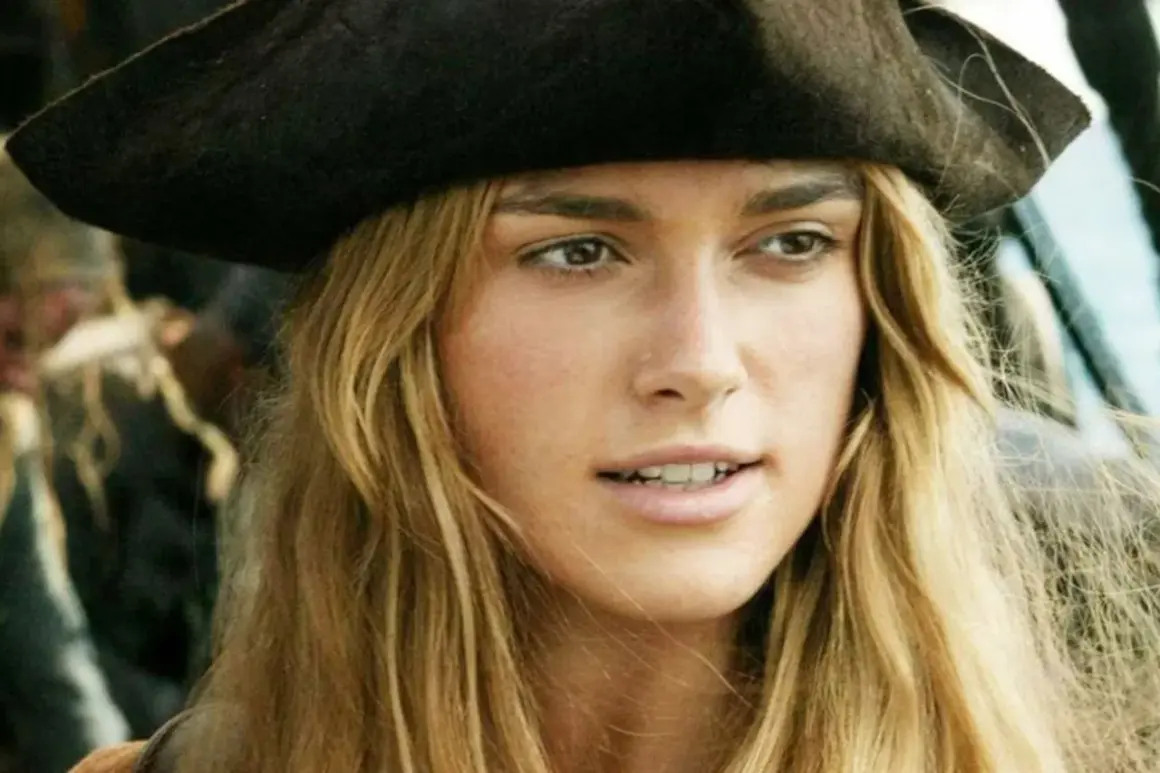Elizabeth Swann z obsady "Piraci z Karaibów" w pirackim kapeluszu, z rozwianymi blond włosami.