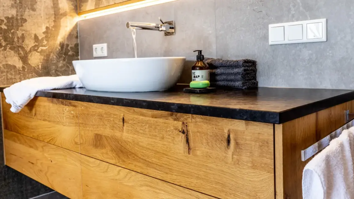 Modernes Badezimmer mit Waschtischunterschrank aus massivem Holz. Die Schubladenfronten zeigen die natürliche Maserung des Holzes, eine tolle Idee für Ihr Bad.