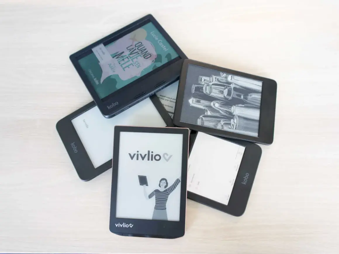 Pile d'e-readers Kobo et Vivlio, certains affichant des couvertures de livres ou des illustrations. Le logiciel Kobo est visible sur plusieurs appareils.