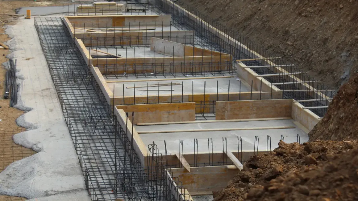 Szkielet zbrojeniowy i szalunki drewniane czekają na beton. Tak wygląda budowa fundamentów krok po kroku.