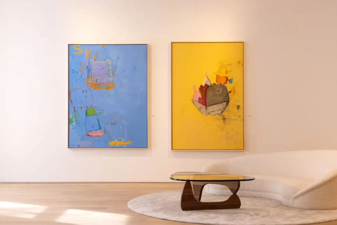 Two vibrant paintings, showcasing playful figures and abstract elements, exemplify modern art trends. A plush sofa and unique coffee table complete the stylish scene.