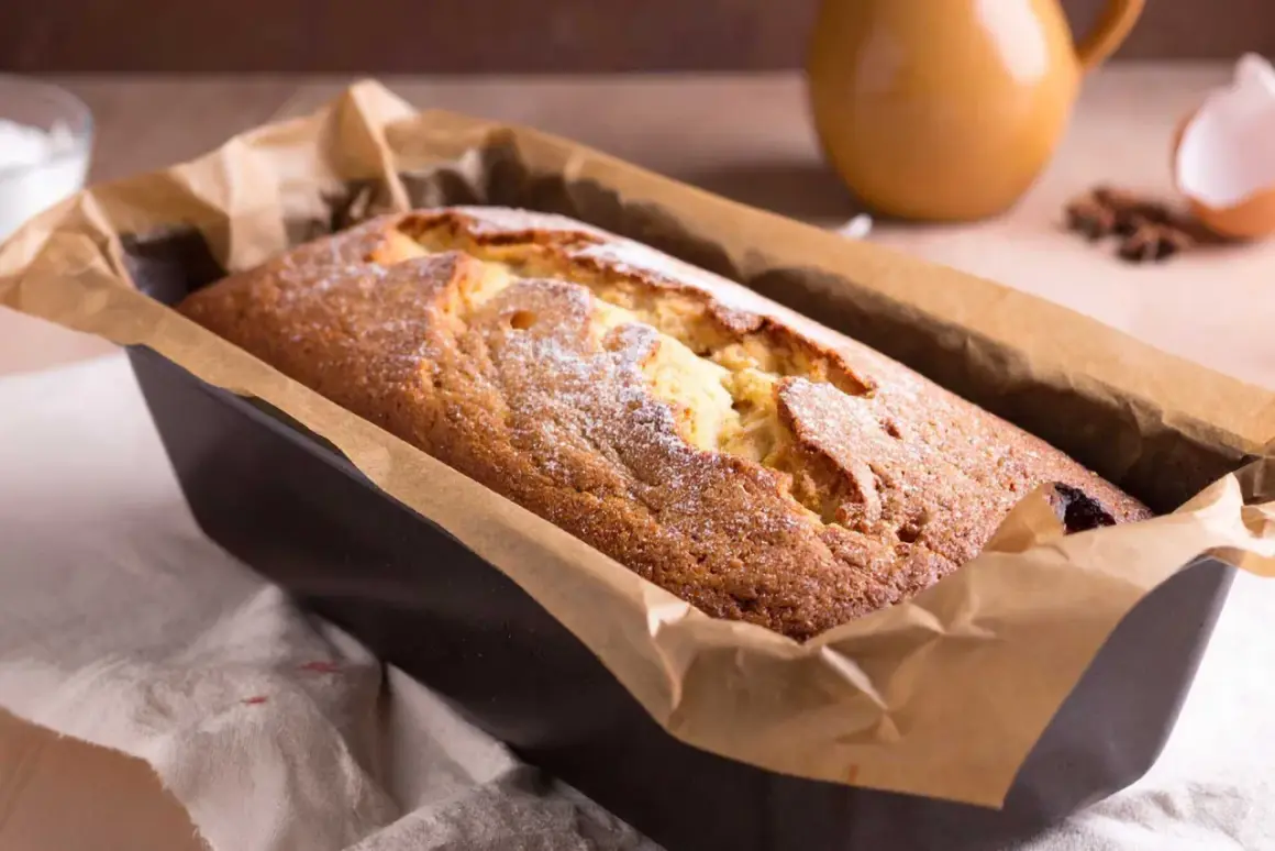 Frisch gebackener Kuchen in einer Kastenform, mit Puderzucker bestäubt. Ein köstlicher Anblick, der zum Reinbeißen einlädt. Dreh dich um, Kuchen, du bist perfekt!