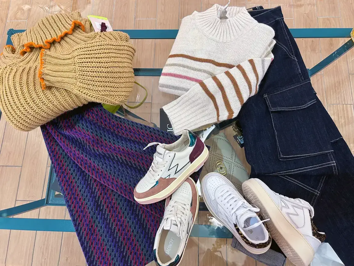 Sneakers: cosa sono? Scarpe comode e alla moda, perfette per ogni outfit. Ecco un esempio di look casual con maglioni, jeans e una borsa.