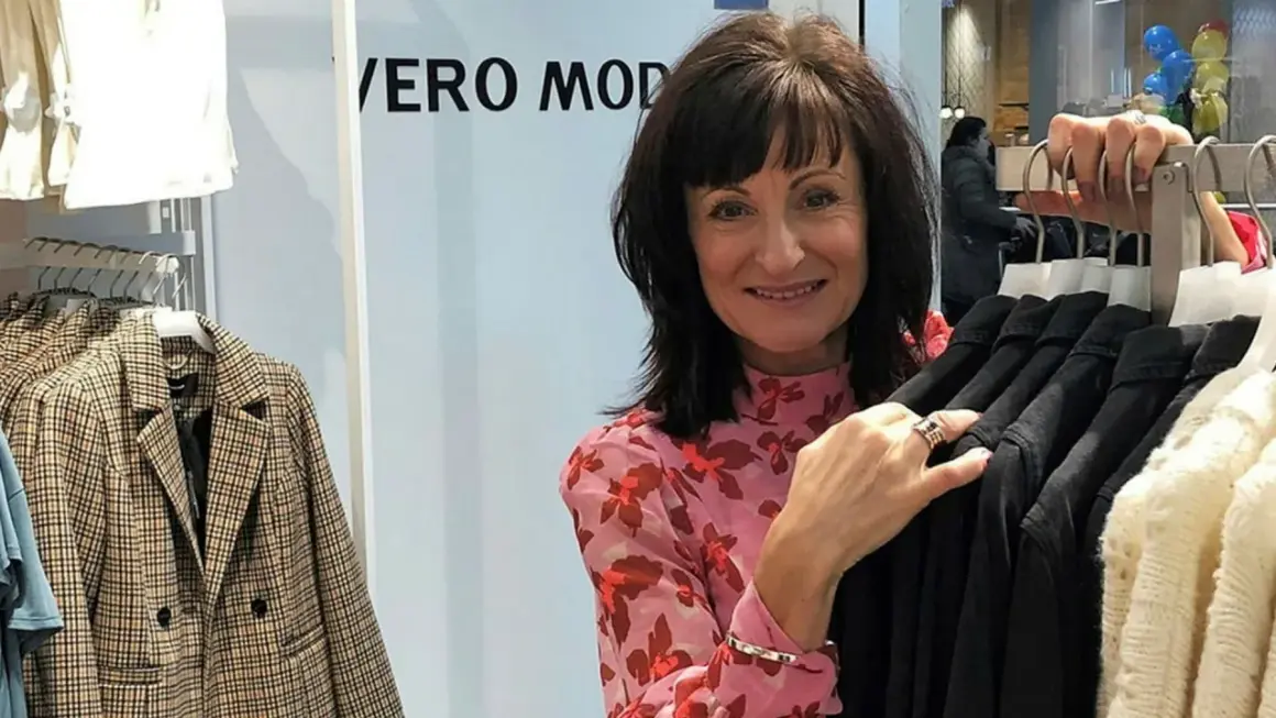 Kvinna i blommig blus vid klädställning med plagg från Vero Moda rea.