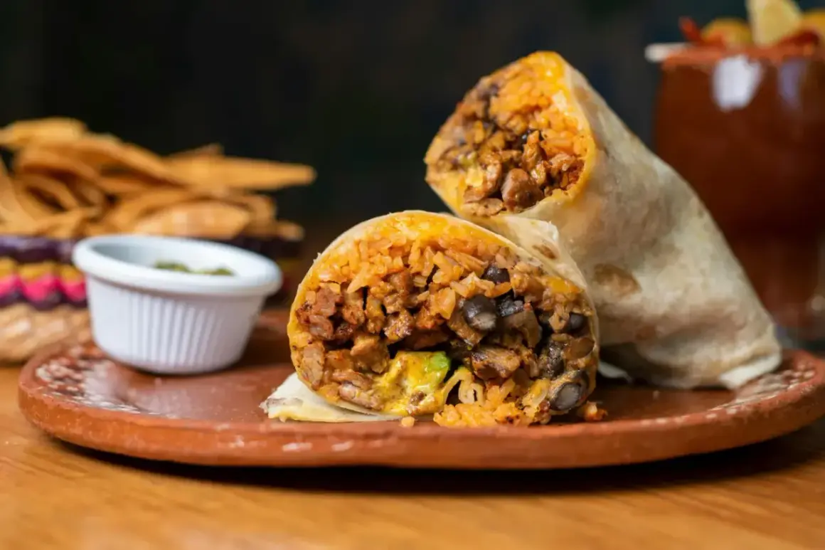 Pyszny burrito z kurczakiem, ryżem i fasolą, podane z salsą i chipsami. Idealne na szybki lunch.