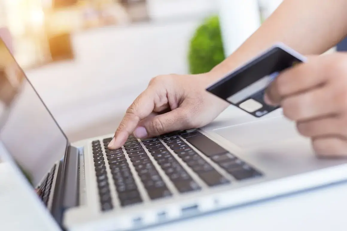 Osoba wpisuje dane karty płatniczej na laptopie, realizując przelewy przychodzące BNP Paribas.