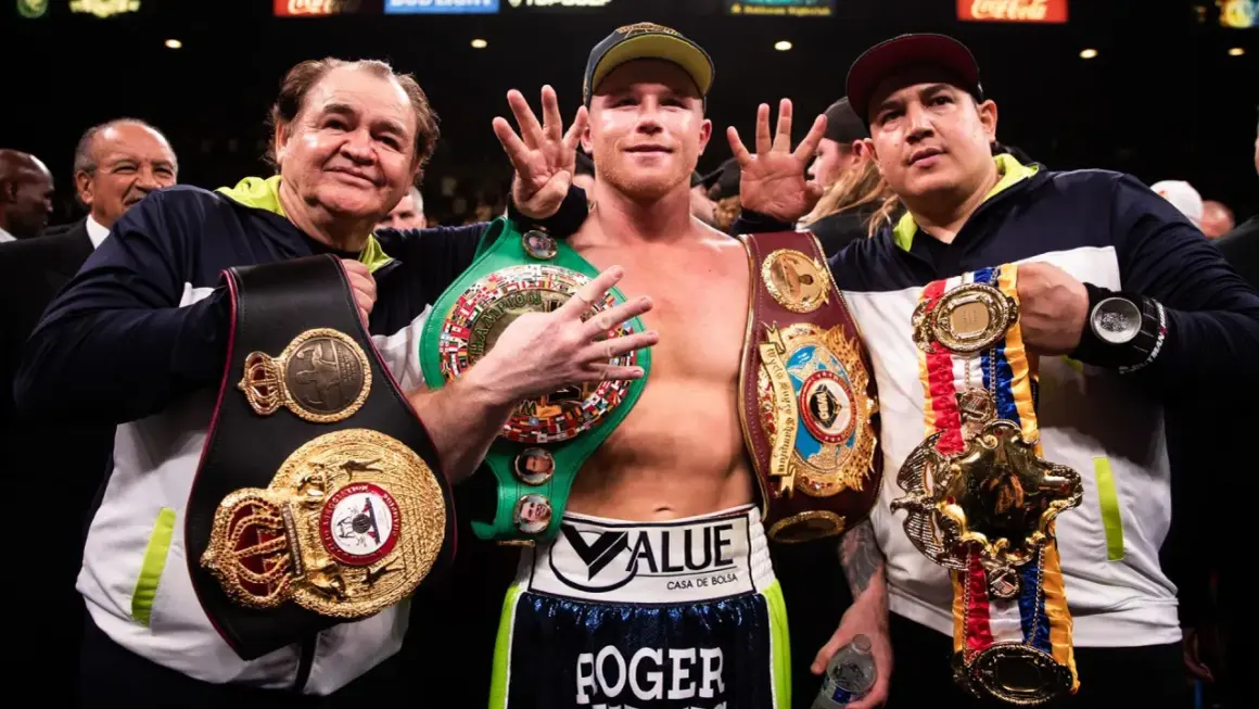 Canelo Alvarez, surrounded by his team, proudly displays his championship belts, a testament to his incredible record.