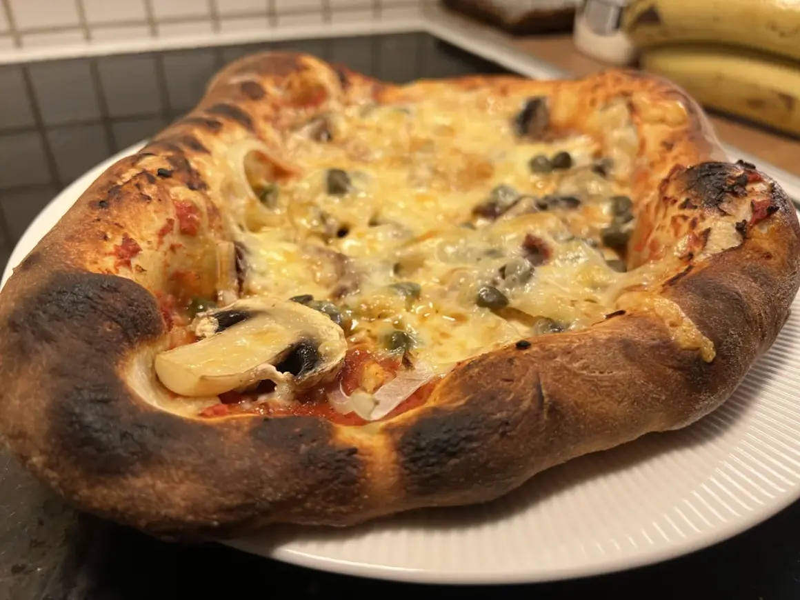 En nybakad pizza med svamp och kapris, perfekt för ett mysigt kvällsmål. Detta är ett fantastiskt pizza recept!