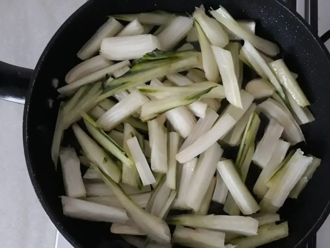 Coste di sedano tagliate a bastoncini e pronte per essere saltate in padella.