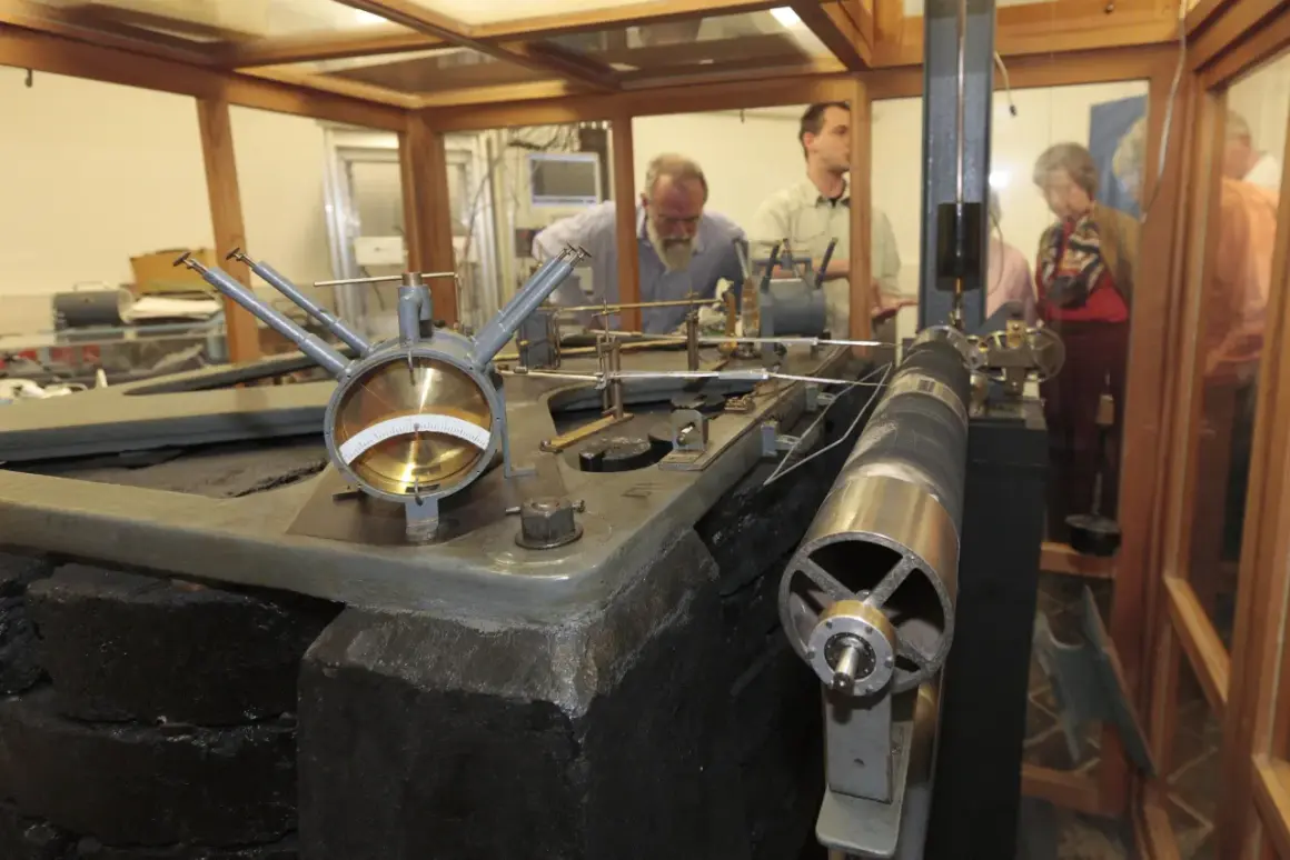 Seismograph in der Erdbebenwarte Bensberg. Besucher betrachten die historische Technik zur Messung von Erdbeben.