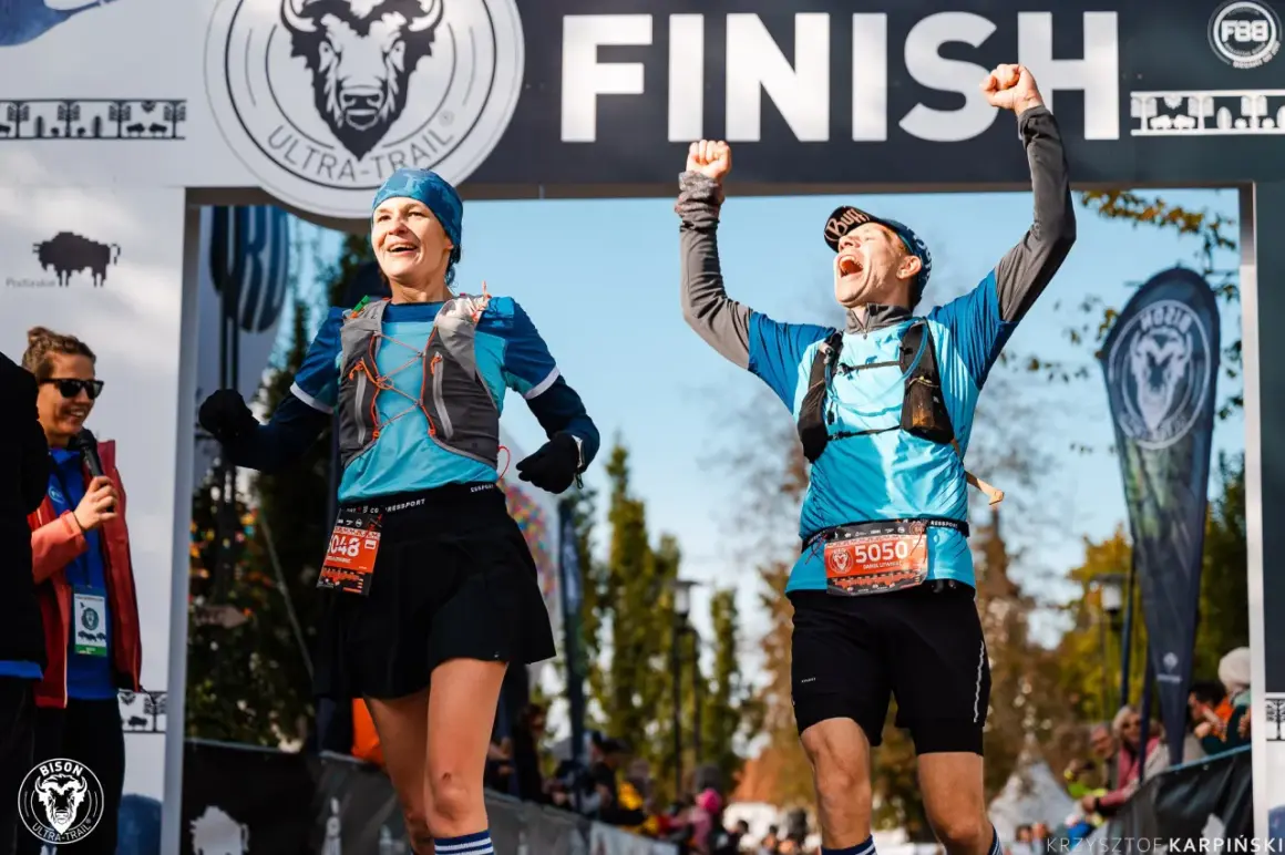 Dwaj biegacze z radością przekraczają linię mety Bison Ultra-Trail Supraśl.