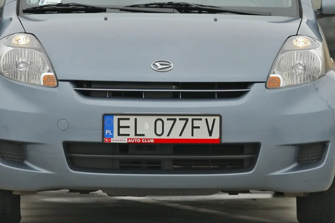 Szara tablice el. EL 077FV z logo Daihatsu Auto Club.