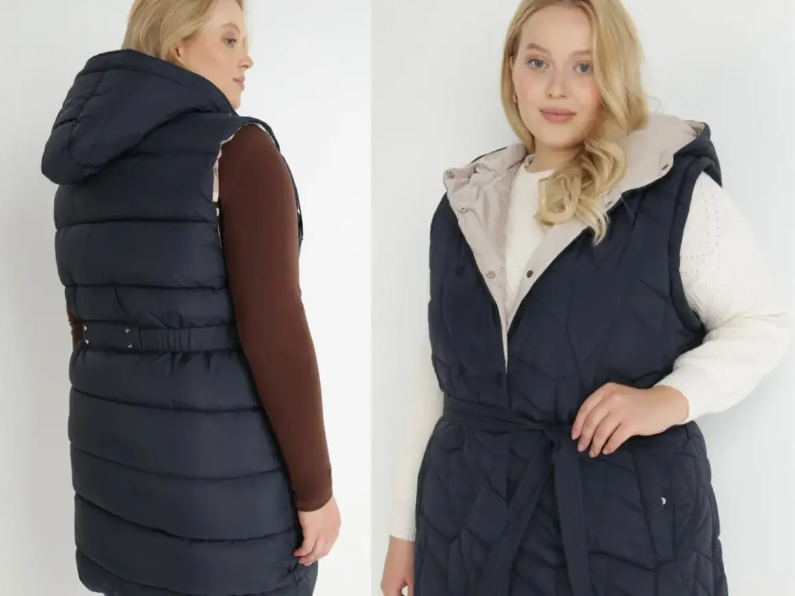 Dwie modelki plus size prezentują granatową, pikowaną kamizelkę z kapturem i paskiem.