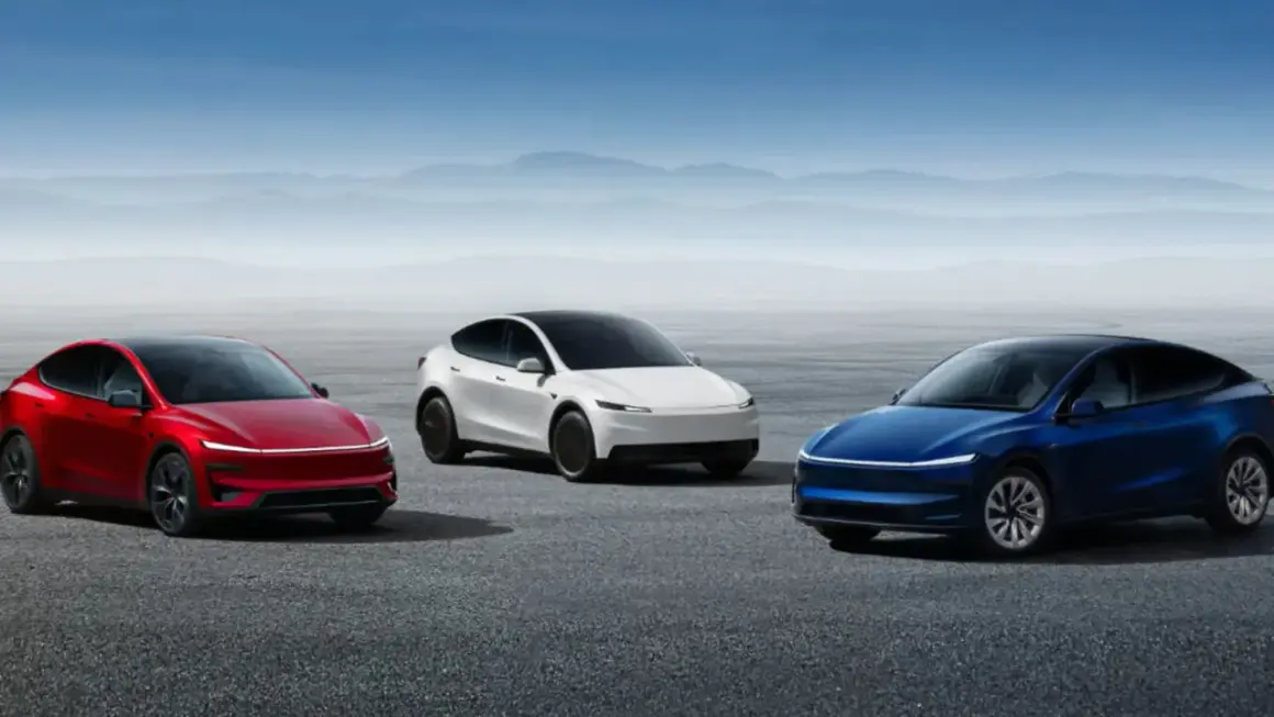 Trzy samochody Tesla: czerwony, biały i niebieski, stoją na pustkowiu.
