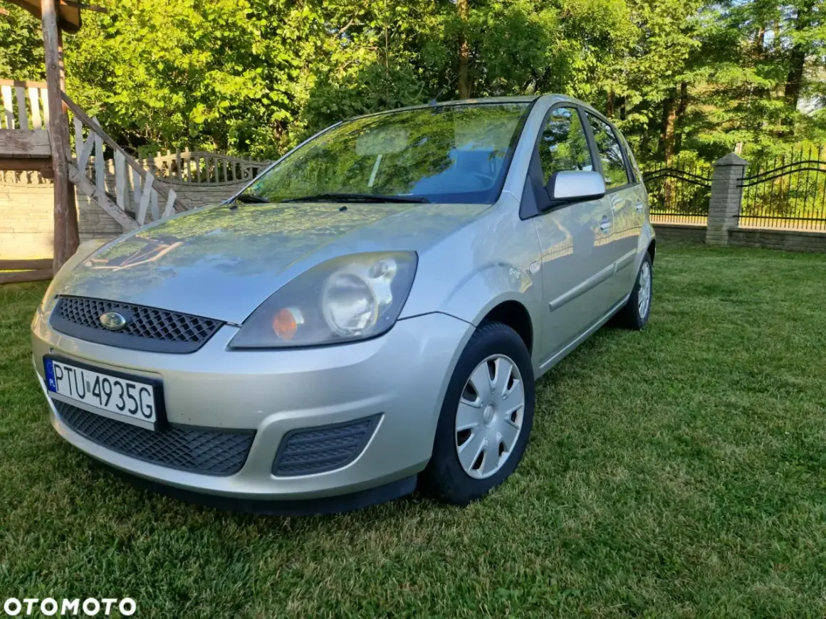 Srebrny Ford Fiesta Mk5 na trawniku, z widocznym numerem rejestracyjnym PTU 4935G.
