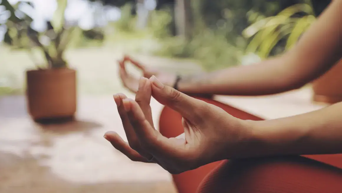 Manos en posición de meditación, con el pulgar e índice unidos, un mudra de energía.