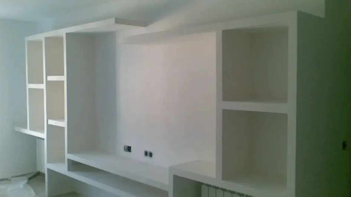 Parete attrezzata fai da te in cartongesso, con vani a giorno e mensole, pronta per accogliere TV e oggetti.