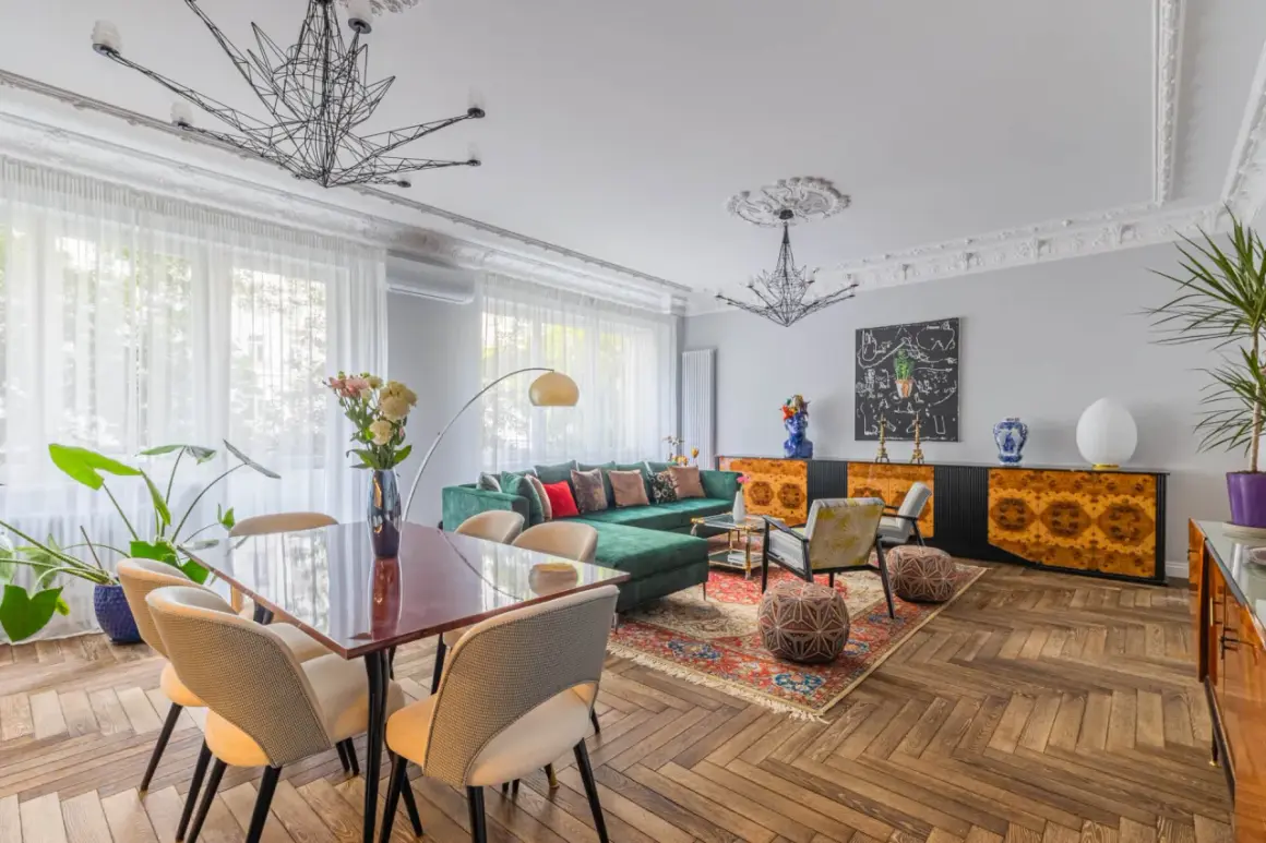 Elegancki salon z zieloną kanapą i jadalnią, idealny do zamieszkania. Ten dom na sprzedaż w Krakowie zachwyca stylem.