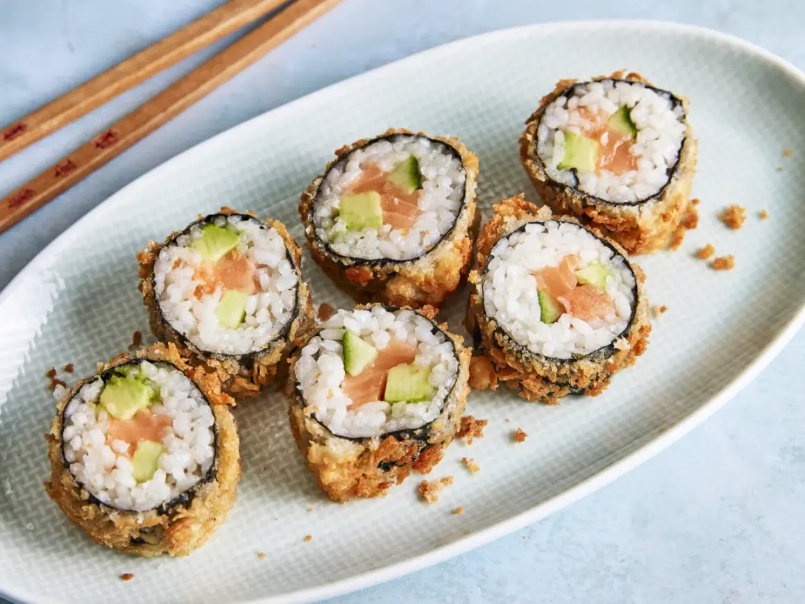 Knuspriges Tempura Sushi mit Lachs und Avocado auf einem Teller, bereit zum Genießen.