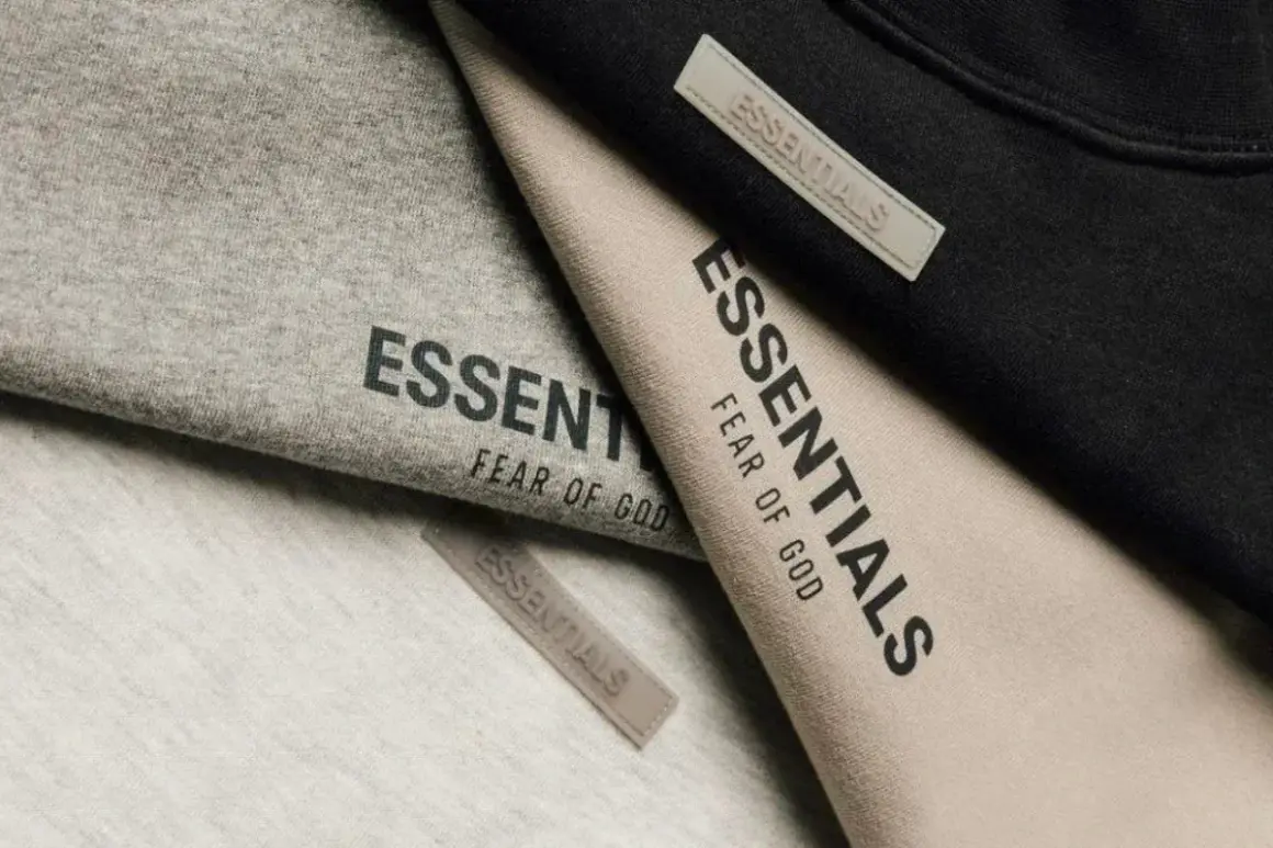 Ubrania marki Essentials, znanej z minimalistycznego stylu i jakości, w odcieniach szarości, beżu i czerni.