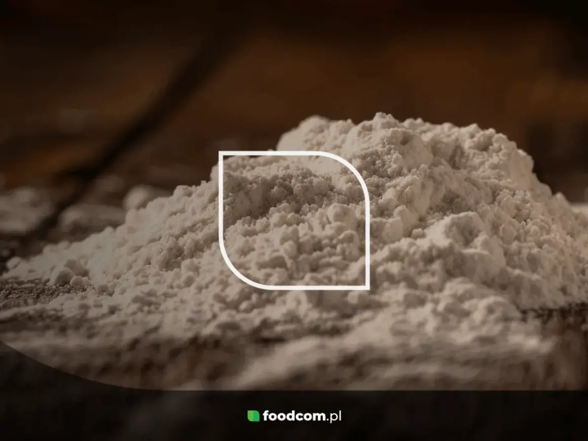 Stos białego proszku, być może mąki, z widocznym logo foodcom.pl. Ten ci 77891 jest idealny do wypieków.