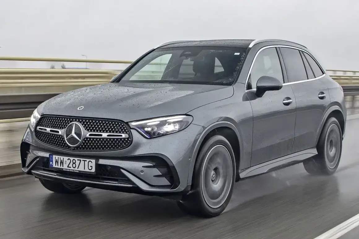 Szary Mercedes GLC 300d na mokrej drodze, z widocznymi kroplami deszczu na karoserii.