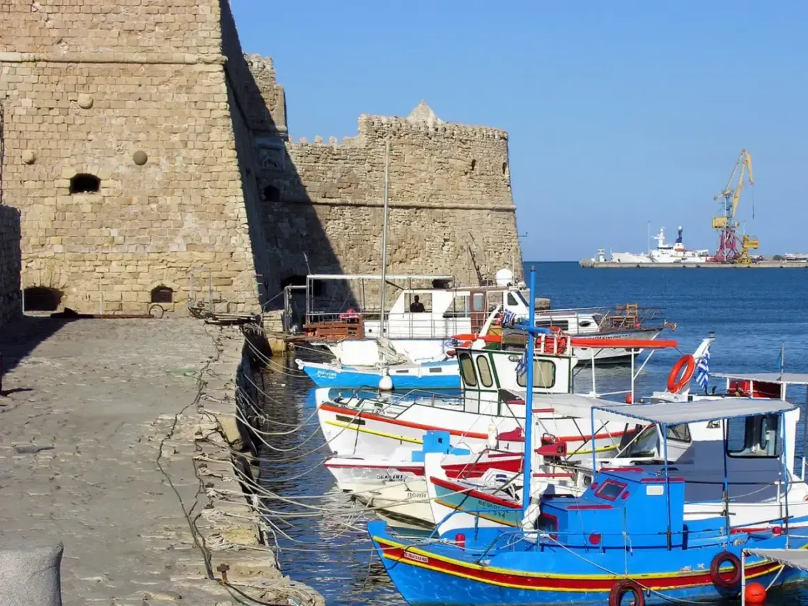 Port w Rethymno, Kreta. Listopad. Słoneczna, choć chłodna pogoda sprzyja spacerom po nabrzeżu wśród kolorowych łodzi rybackich i potężnej twierdzy.