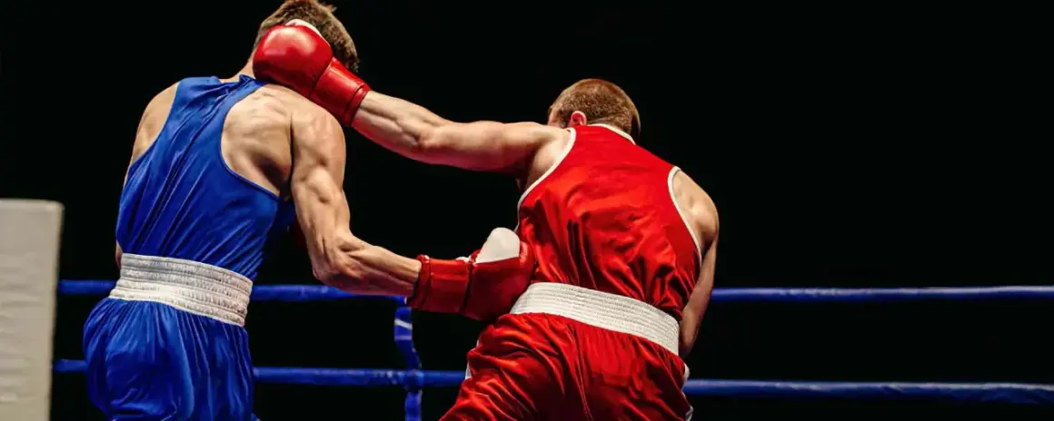 Boxers in a ring. The boxer in red throws a punch, showing how to know if your southpaw or orthodox by their stance.