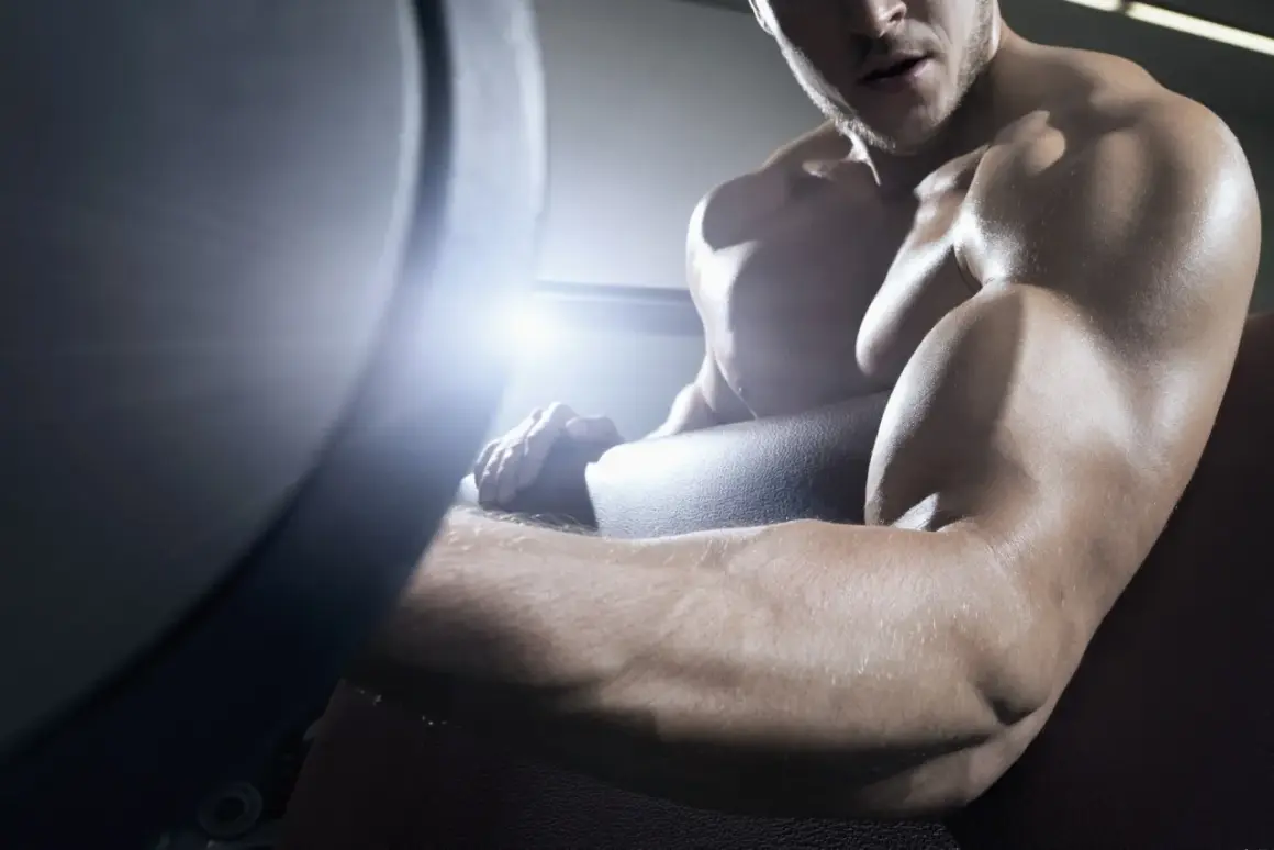 Muskulöser Mann trainiert im Fitnessstudio, seine Arme sind definiert und ohne Fettansatz.