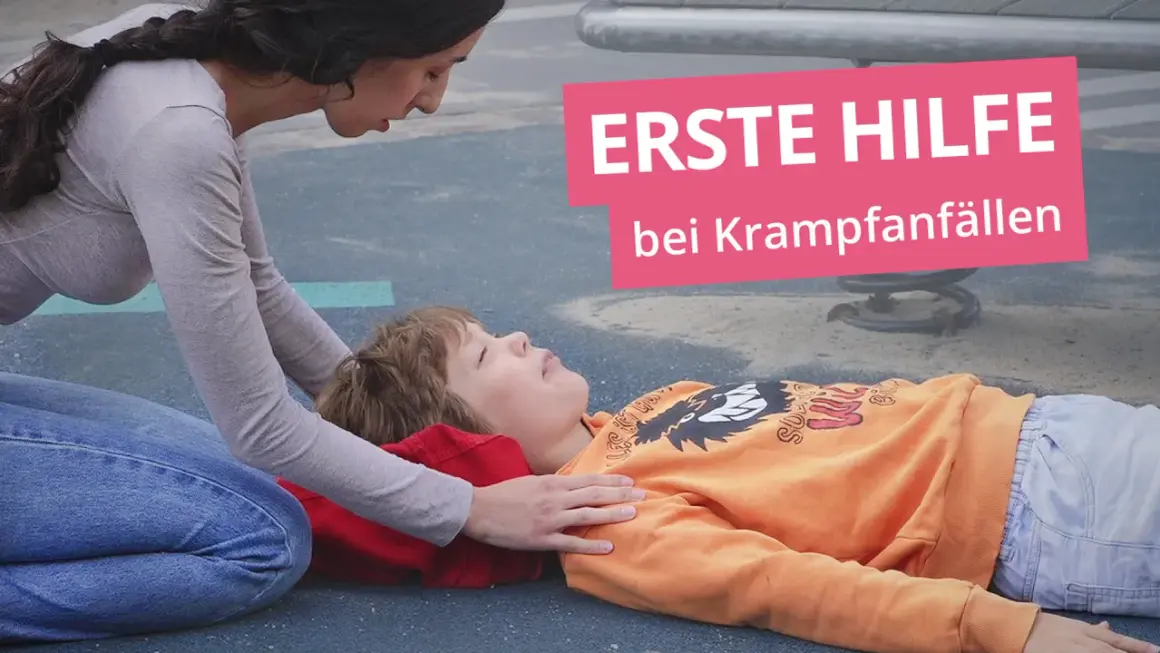 Erste Hilfe bei Krampfanfällen: Eine Frau kniet neben einem Kind, das auf dem Boden liegt.