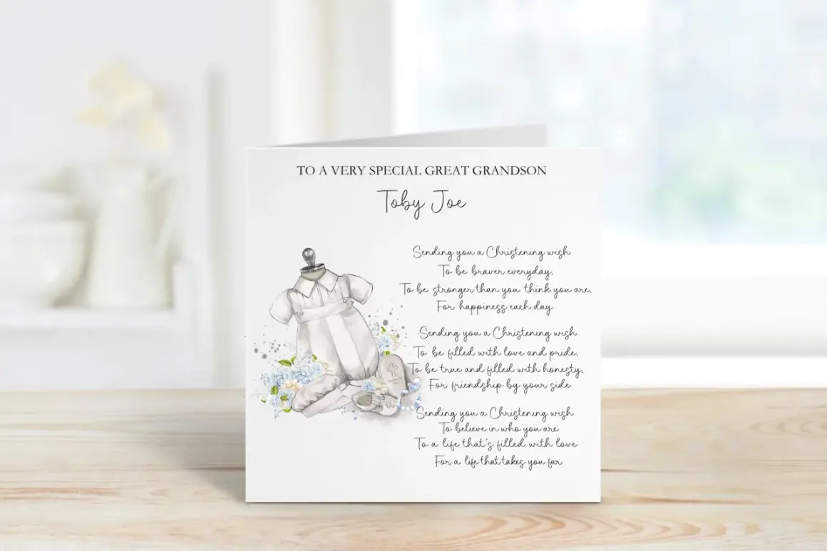 Carte de baptême pour Toby Joe, avec une tenue de bébé et des fleurs bleues. Un doux message de baptême pour un petit-fils.