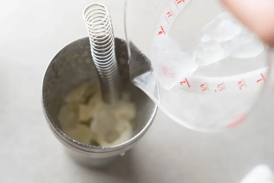 Do shakera z lodem i składnikami na drinka dodawana jest woda. Powstaje pyszny vodka sour.