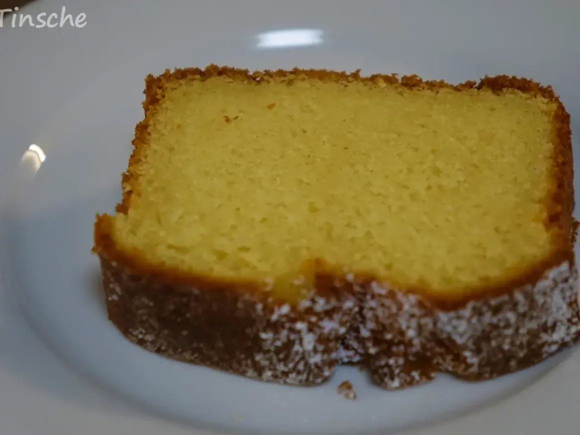 Ein saftiges Stück Kuchen mit Dinkelmehl und Quark, leicht mit Puderzucker bestäubt.