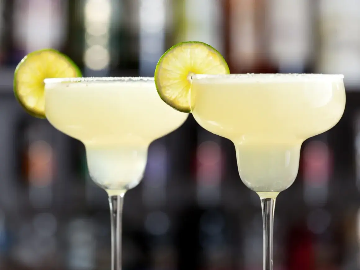 Två frostiga margaritas med saltkant och lime. Perfekt för en varm sommardag.