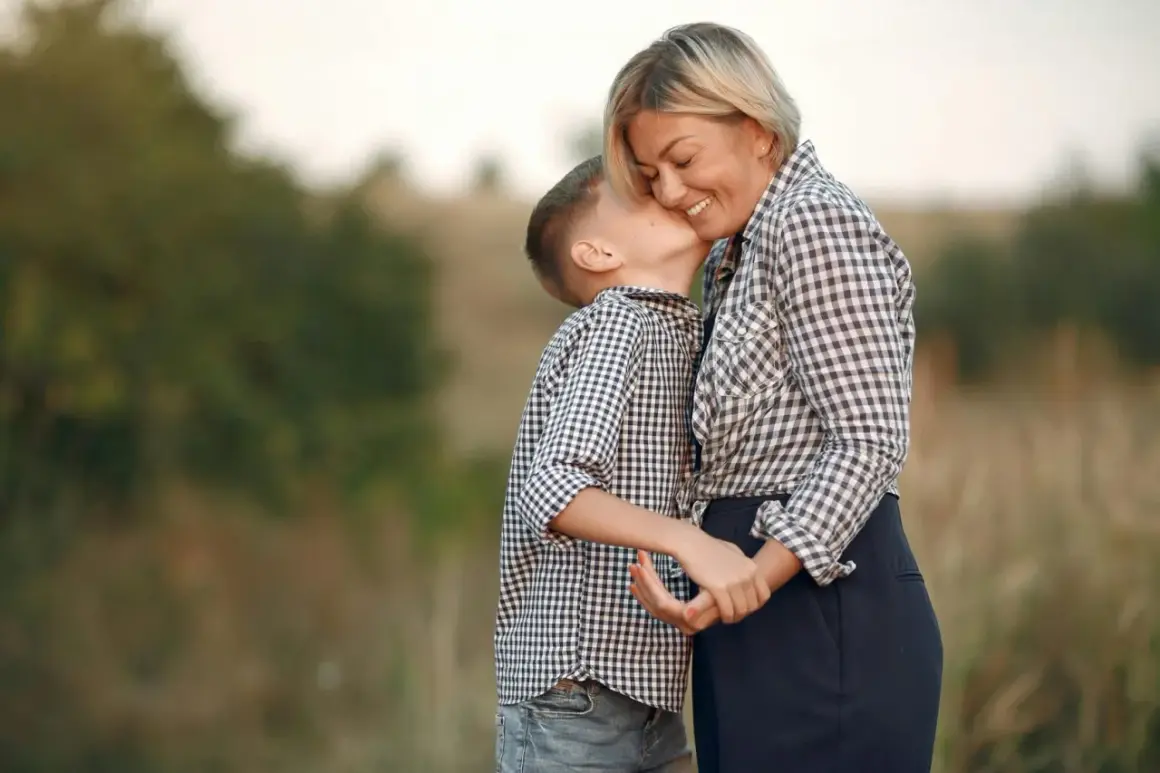 Un bambino bacia la guancia della madre, un gesto d'amore che dimostra che chi ha la mamma è ricc e nun o sap, una vera poesia.