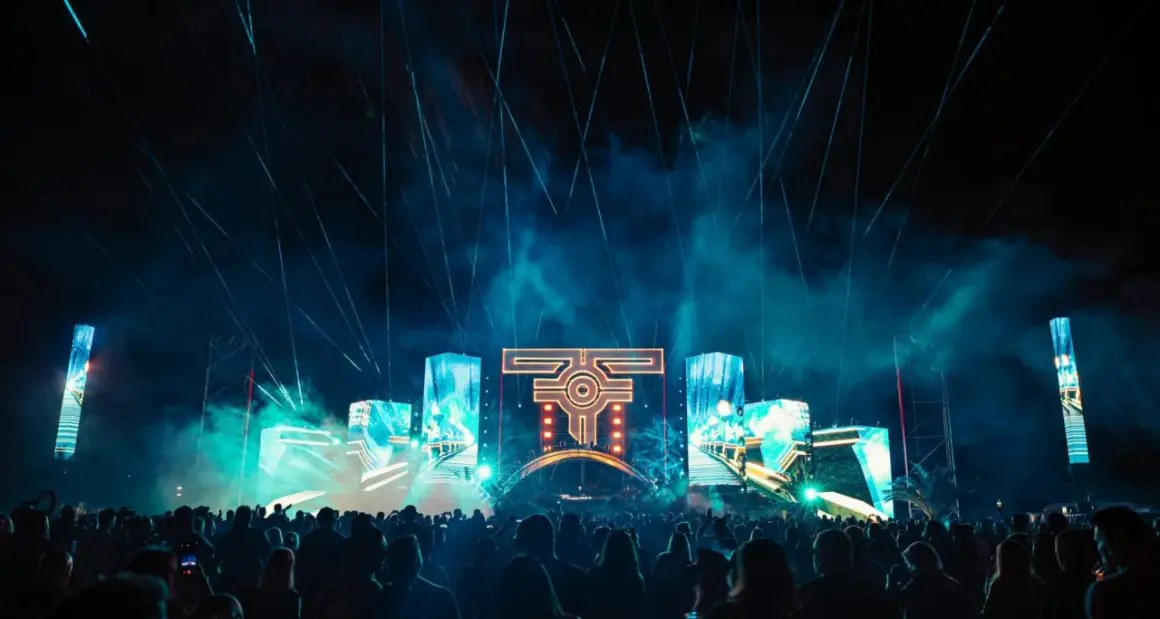 Nocny festiwal muzyczny z laserami i ekranami LED. Tłum ludzi bawi się przy muzyce na żywo.
