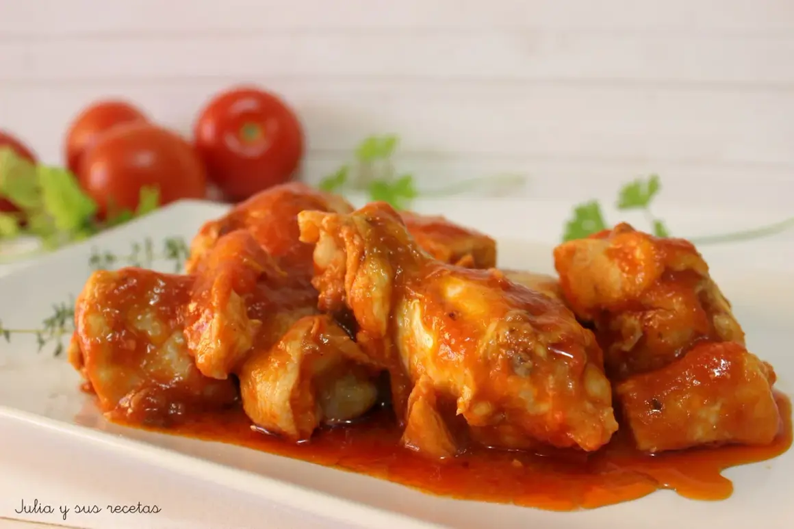 Sabroso pollo con tomate, cocinado a fuego lento hasta que esté tierno y jugoso, servido en una salsa roja vibrante.