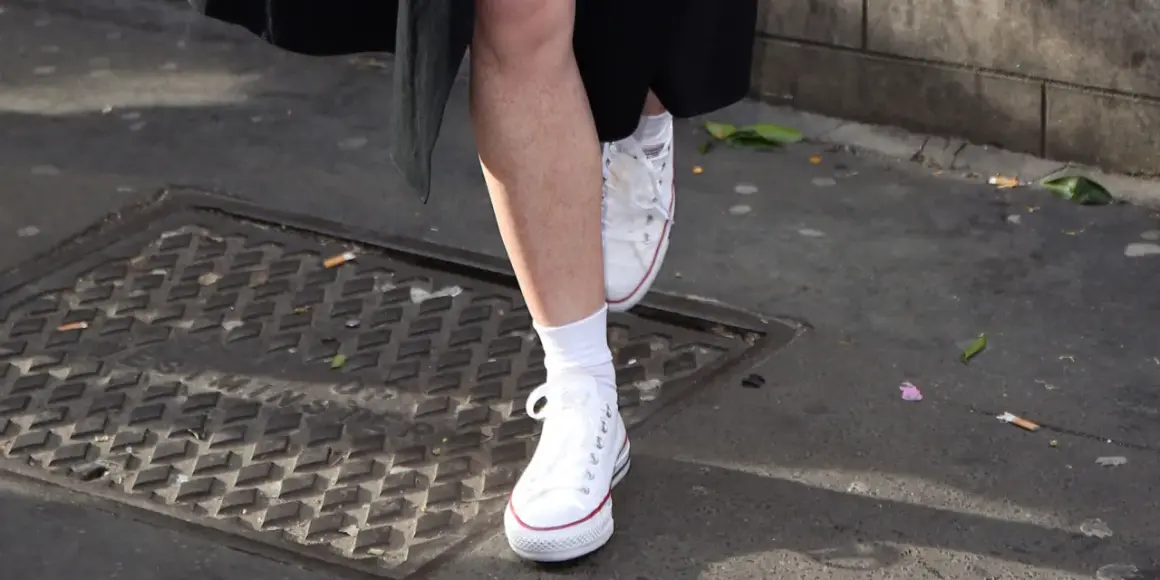 Piedi con calzini bianchi e Converse bianche, un esempio di come lavare le Converse bianche per mantenerle impeccabili.