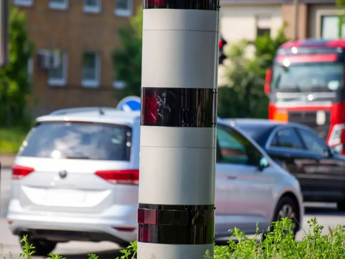 Ein Blitzer ohne Blitz: Dieses Gerät überwacht den Verkehr. Autos fahren vorbei, ein roter LKW ist im Hintergrund zu sehen.