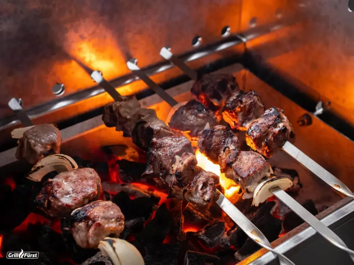 Fleischspieße mit Zwiebeln brutzeln über glühender Kohle. Perfekt, welches Fleisch zum Grillen!