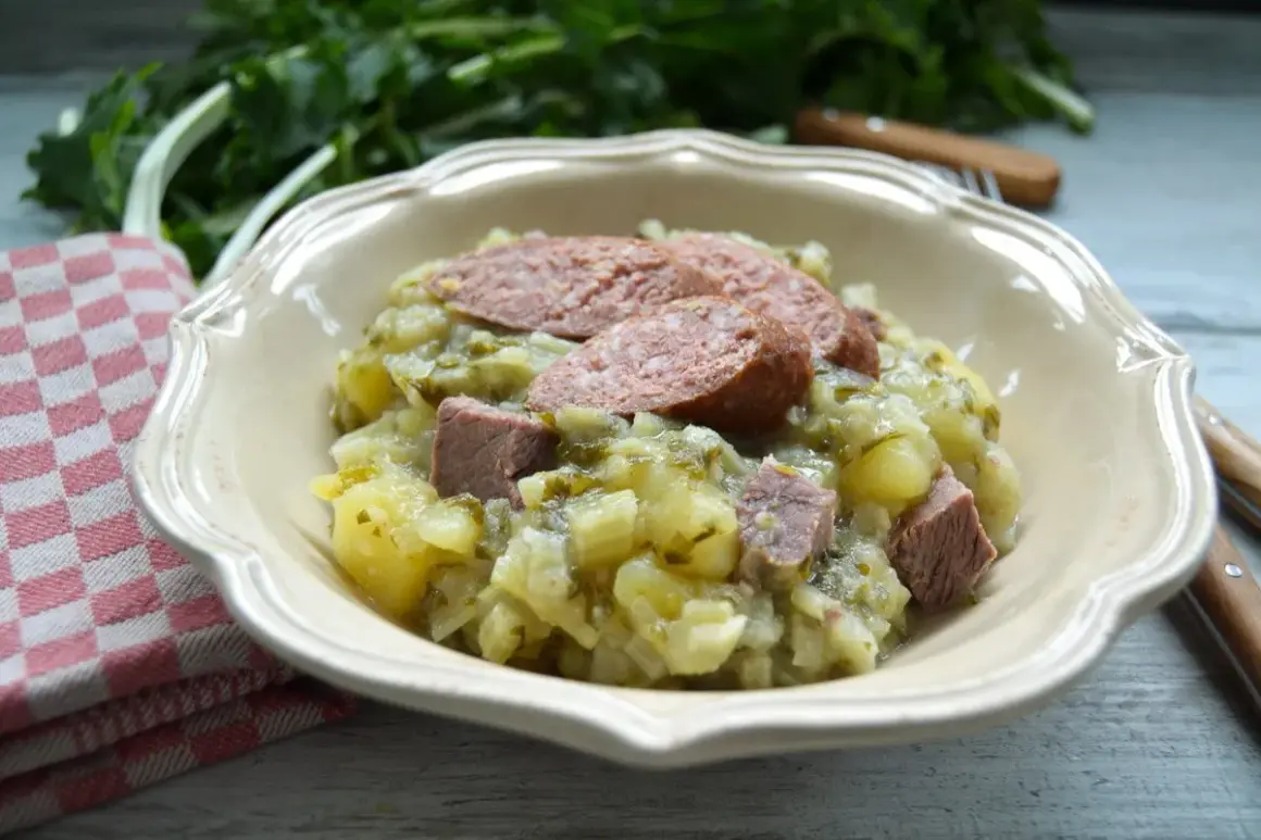 Herzhaftes Stielmus mit Kartoffeln und Wurst in einer Schüssel, daneben ein kariertes Tuch.