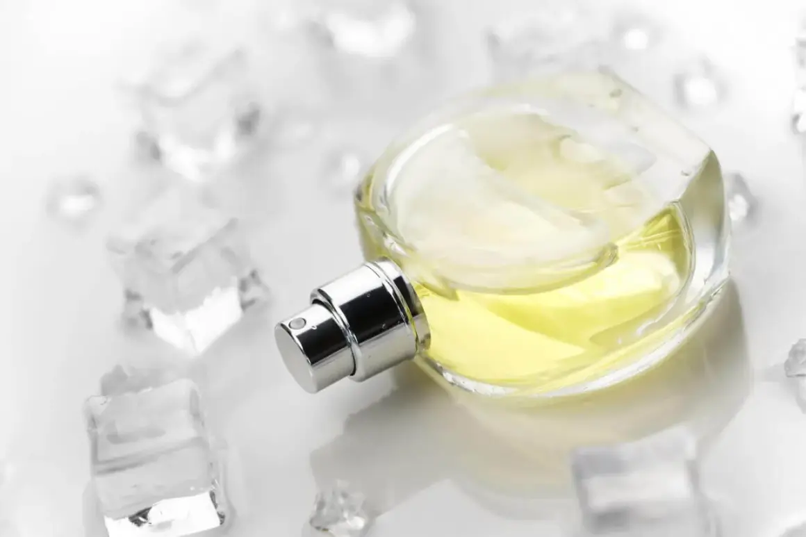 Eleganckie szyprowe perfumy w szklanej butelce, otoczone kostkami lodu, sugerują orzeźwiający, chłodny zapach.