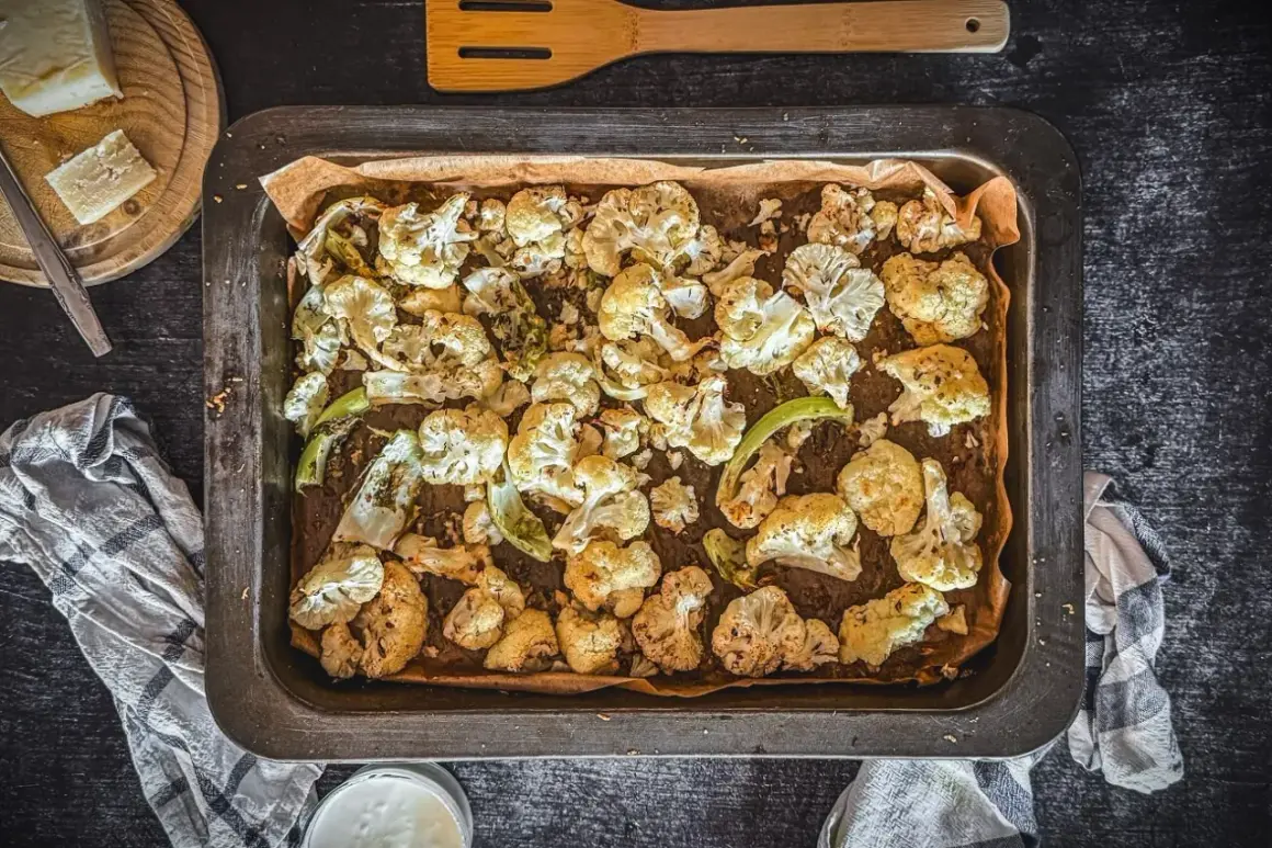 Goldbrauner blumenkohl im backofen, knusprig und aromatisch, bereit zum Genießen. Daneben ein Stück Käse und ein Dip.